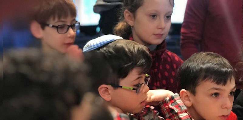 Young Jewish students watching intently.